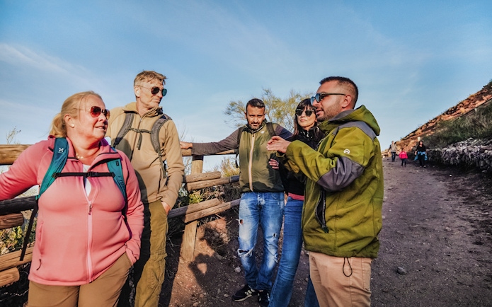 Tourists with guide on Mount Vesuvius trail, Italy.