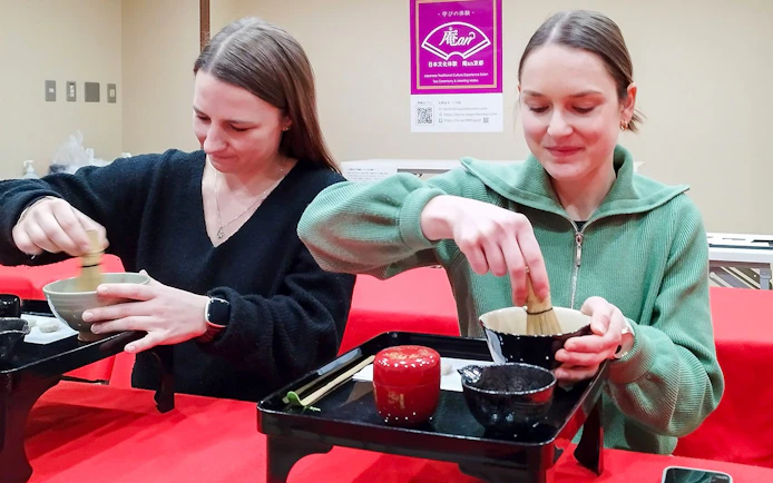 Tourists participating in a tea ceremony in Kyoto's Karasuma area.