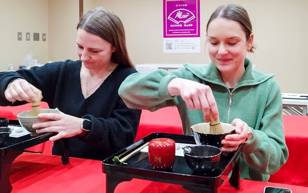 Tourists participating in a tea ceremony in Kyoto's Karasuma area.