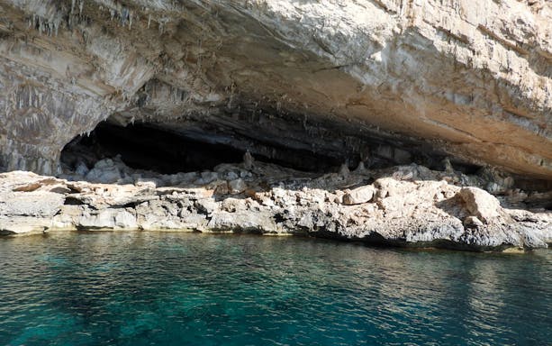 Cave entrance along Costa di Baunei coastline seen from a guided boat tour.