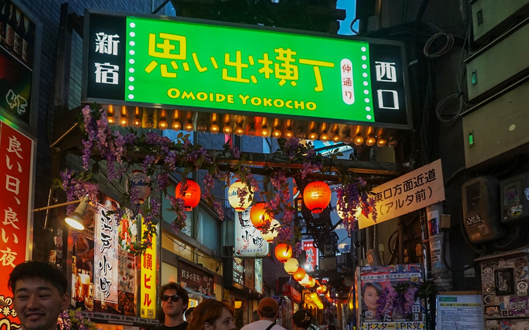 Omoide Yokocho entrance in Shinjuku with lanterns and signs, Tokyo nightlife scene.