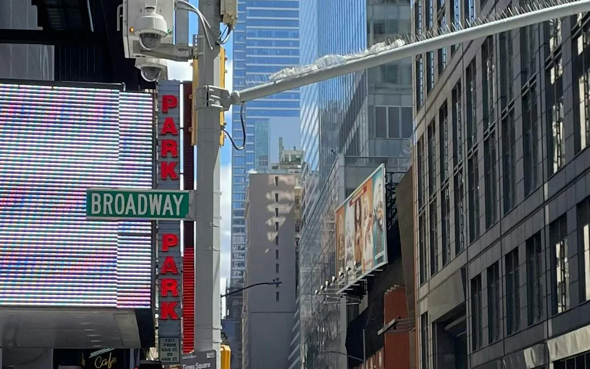 Broadway street sign in Manhattan with tall buildings and billboards, New York City.