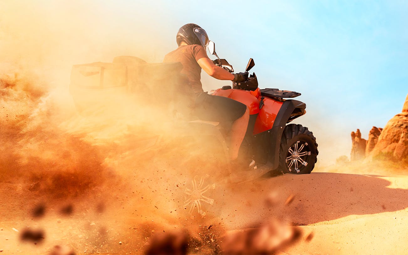 Quad biking through sandy terrain in the Dubai desert.