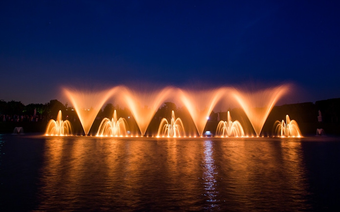 Fountain show at night in the Palace of Versailles gardens, France.