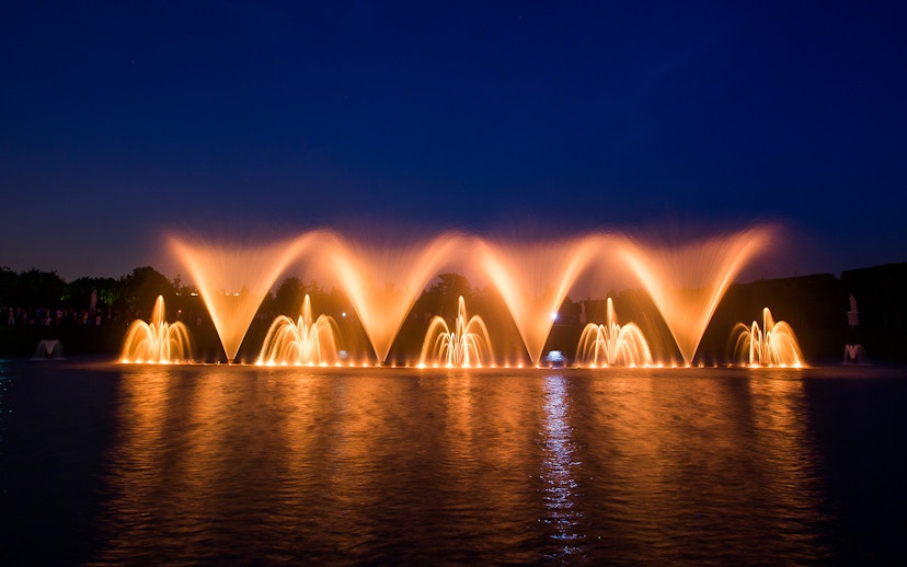 Fountain show at night in the Palace of Versailles gardens, France.