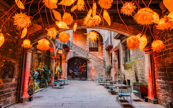 Outdoor seating area at Palau Dalmases Flamenco Show with decorative lights.