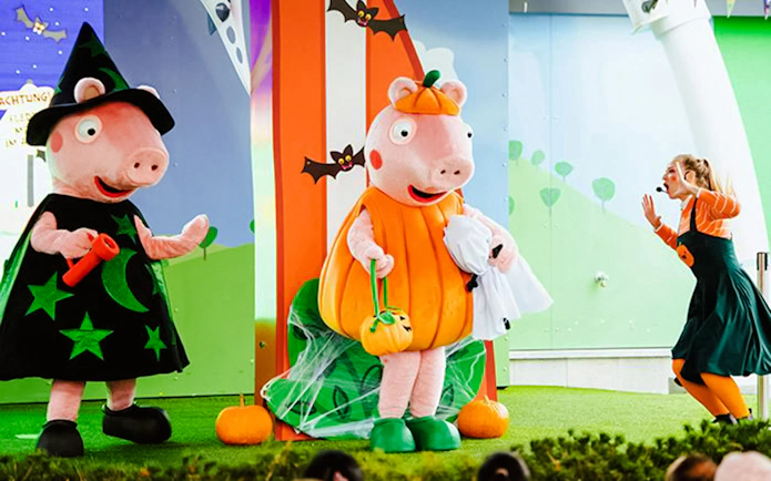 Peppa Pig characters in Halloween costumes at Peppa Pig Park event.