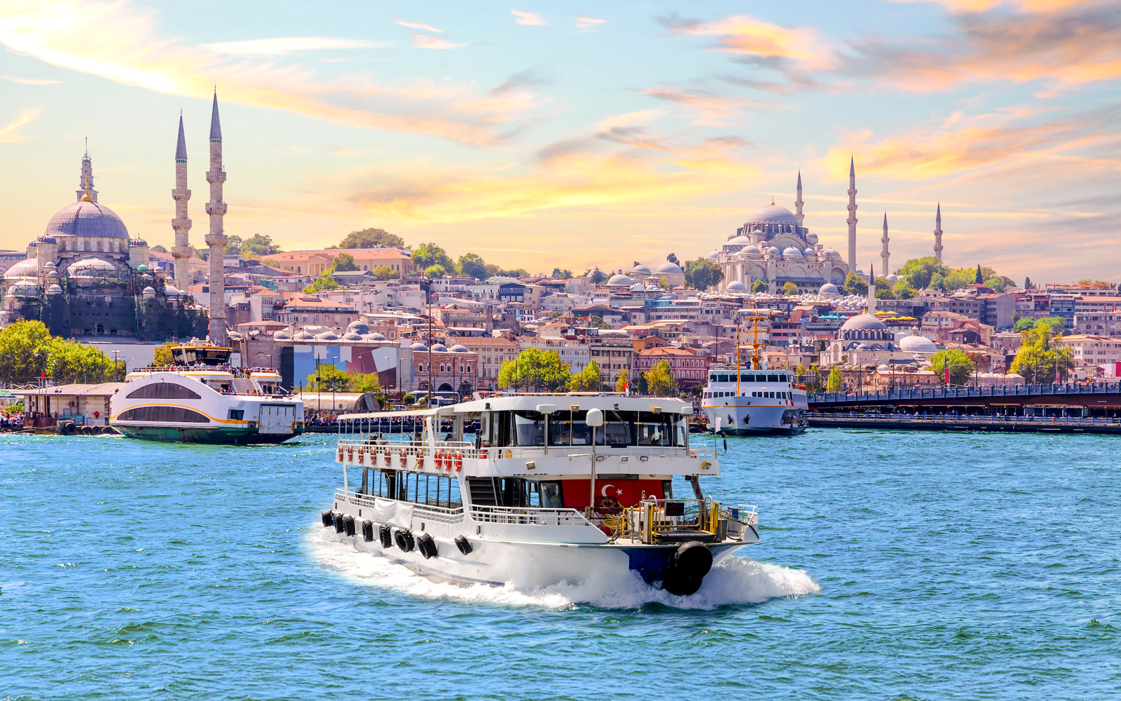 Bosphorus cruise ship sailing with Istanbul skyline and mosques in the background.