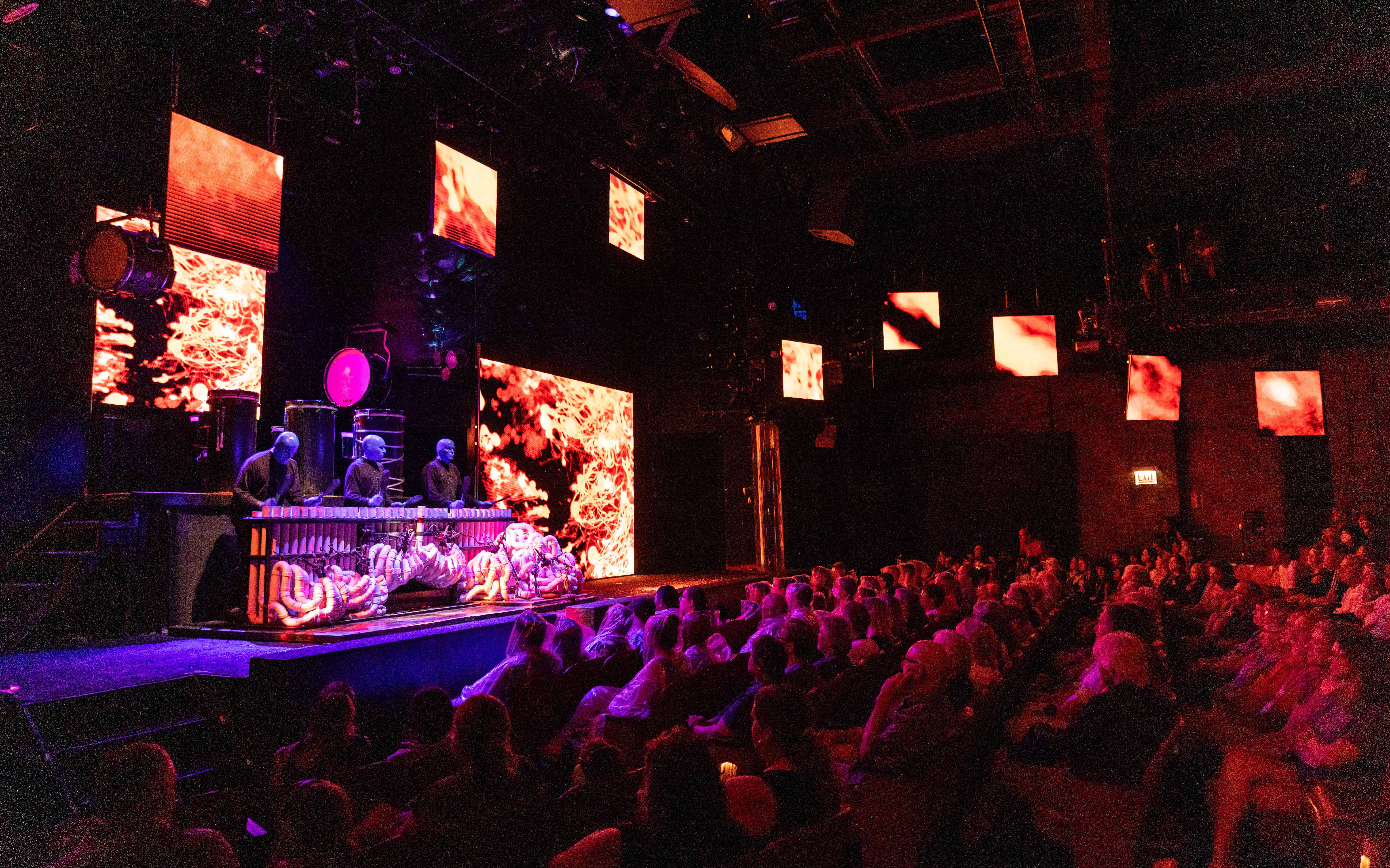 Blue Man Group performing on stage with vibrant visuals in Orlando theater.