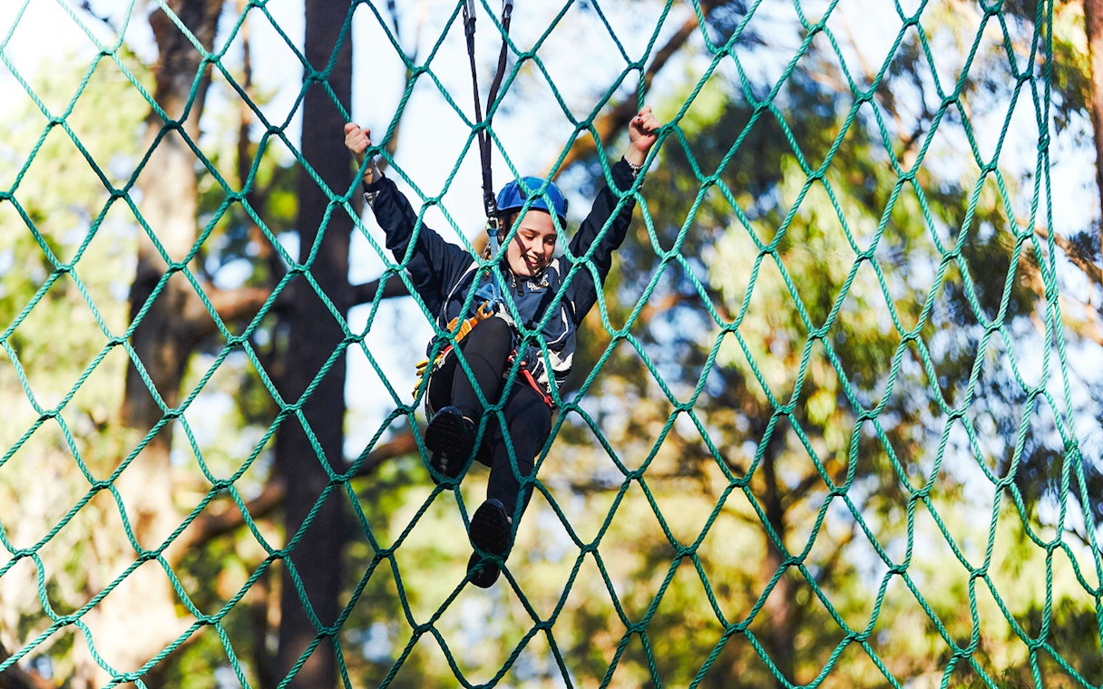 Person climbing a rope net in Ludlow Tuart Forest, Western Australia.