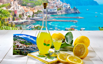 Limoncello bottle with lemons and Positano view, Rome to Positano tour.