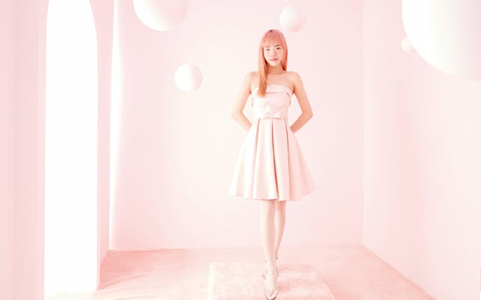 Person in a pink dress posing in a pastel-themed studio in Seoul.