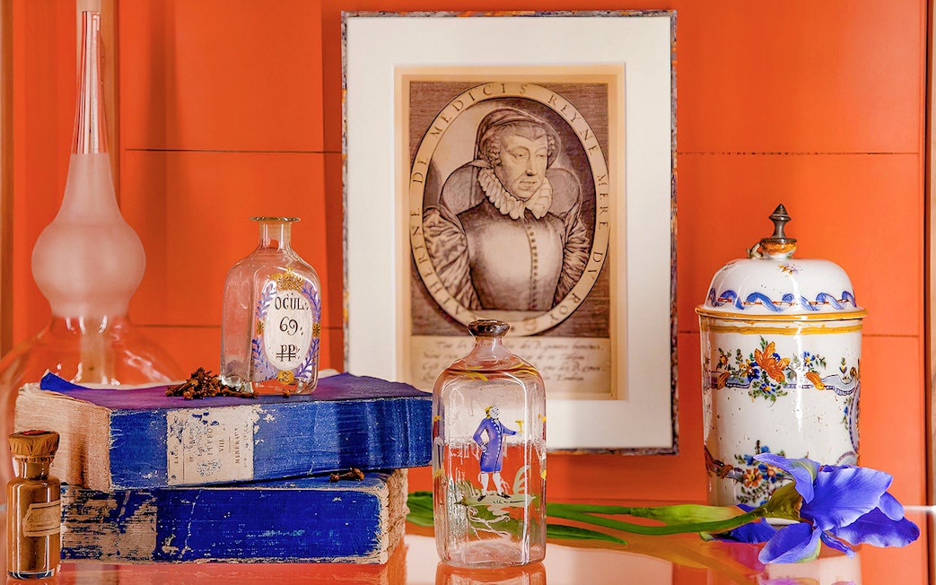 Fragonard Perfume Museum display with vintage bottles, portrait, and decorative jar.