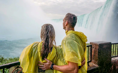 Couple in yellow ponchos at Niagara Falls viewpoint.