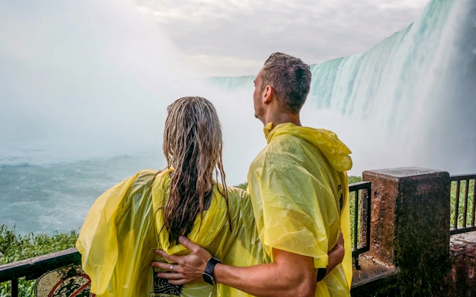 Couple in yellow ponchos at Niagara Falls viewpoint.