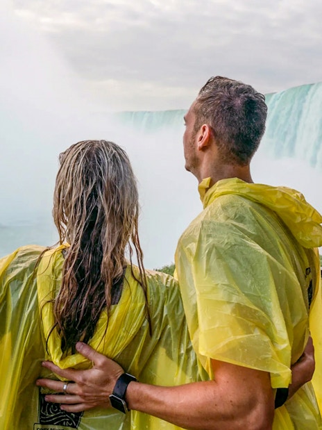 Couple in yellow ponchos at Niagara Falls viewpoint.