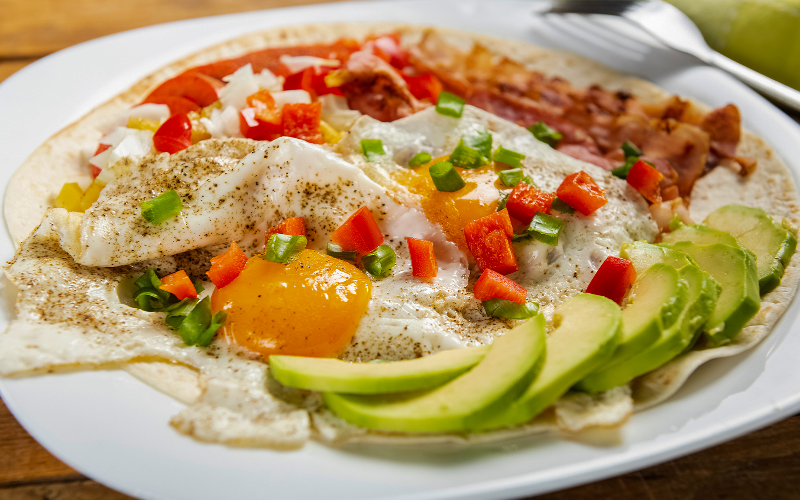 Huevos rancheros dish with eggs, salsa, and tortillas in a Mexican restaurant setting.