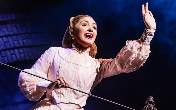 Performer in period costume singing on stage in Sweeney Todd production.