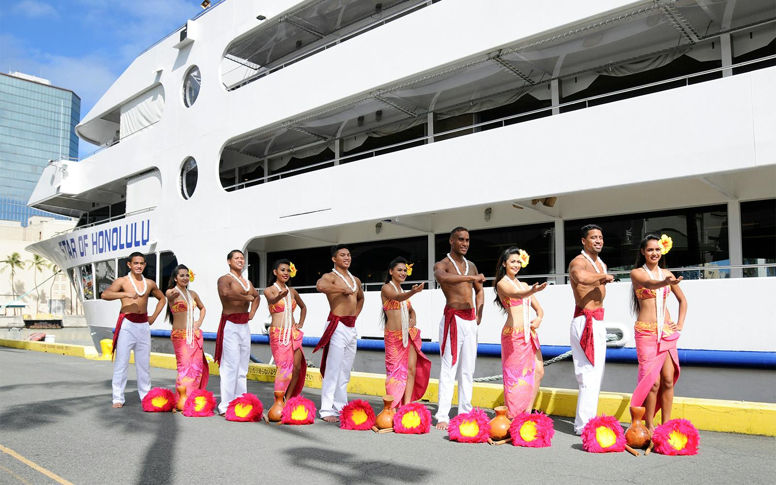 Hula dancers in traditional attire in front of the Star of Honolulu cruise ship, Hawaii.