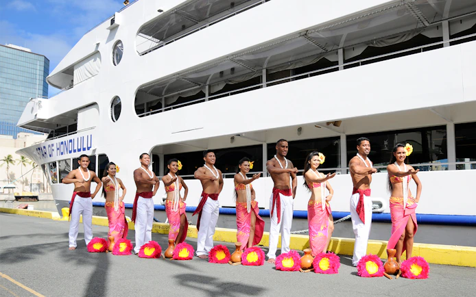 Hula dancers in traditional attire in front of the Star of Honolulu cruise ship, Hawaii.