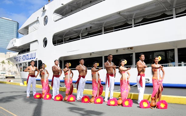 Hula dancers in traditional attire in front of the Star of Honolulu cruise ship, Hawaii.
