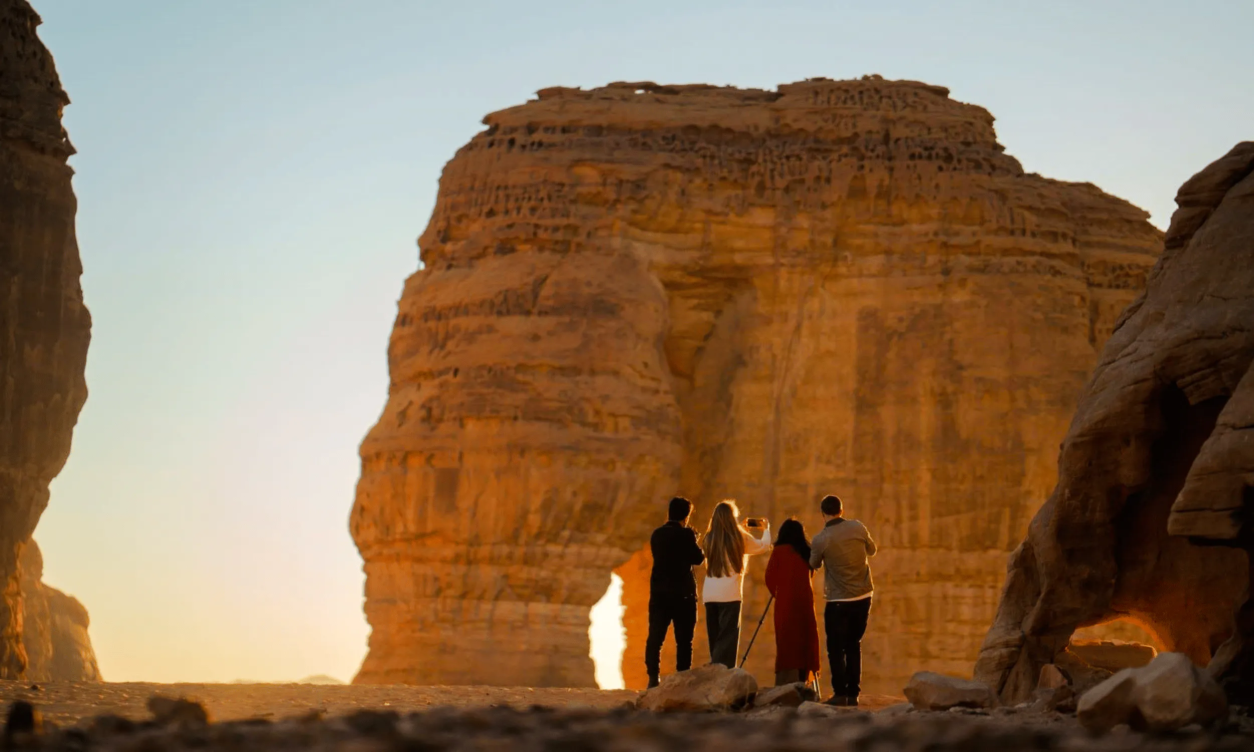 Visitors exploring Hegra rock formations during AlUla day trip from Madinah.