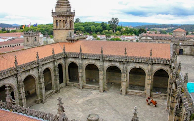 Cloister courtyard of Santiago de Compostela Cathedral, Spain, with arched stone architecture.