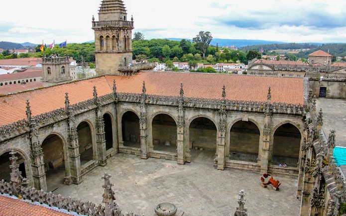 Cloister courtyard of Santiago de Compostela Cathedral, Spain, with arched stone architecture.