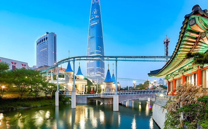 Lotte World park with monorail, traditional Korean architecture, and skyscraper in Seoul.