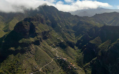 Masca Village nestled in lush green mountains, Tenerife, with winding roads leading to Teide National Park.