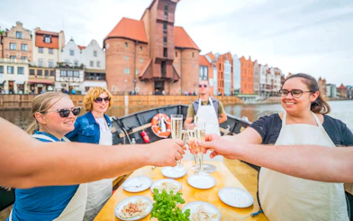 Guests toasting during Pierogi Tasting on Motława River Cruise in Gdansk.