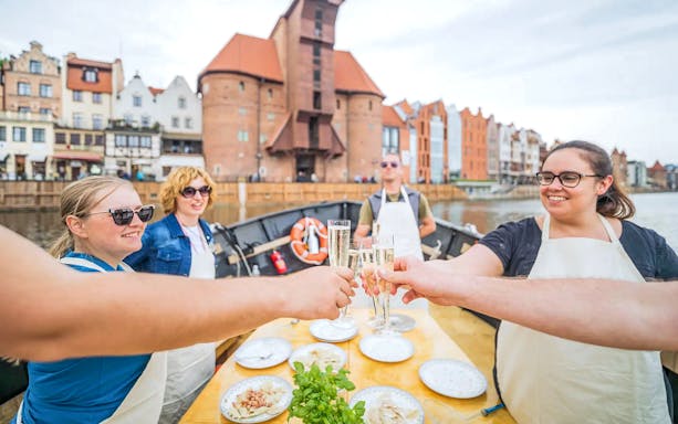 Guests toasting during Pierogi Tasting on Motława River Cruise in Gdansk.