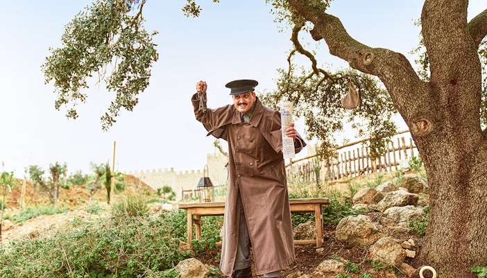 Performer in historical costume at Puy du Fou España park, Spain, engaging in a theatrical reenactment.