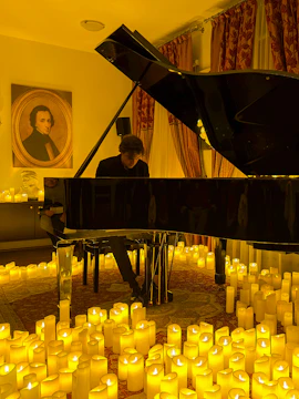 Pianist performing at candlelit Chopin concert in Krakow.