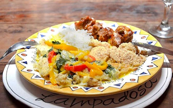 Traditional Brazilian dish with rice, vegetables, and meat served in a Copacabana cooking class, Rio de Janeiro.