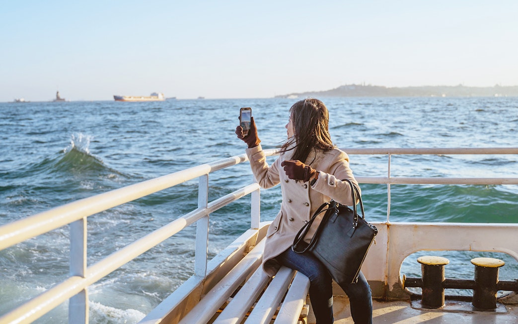 Woman taking photo on Sevilla's Guadalquivir River cruise.