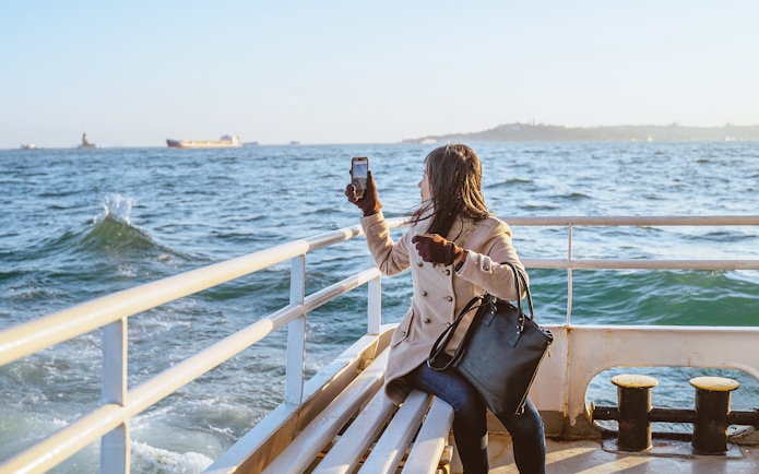 Woman taking photo on Sevilla's Guadalquivir River cruise.