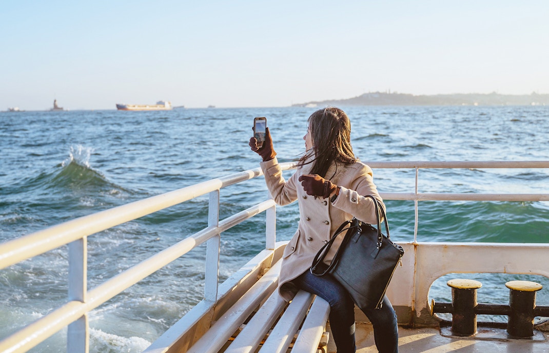 Woman taking photo on Sevilla's Guadalquivir River cruise.