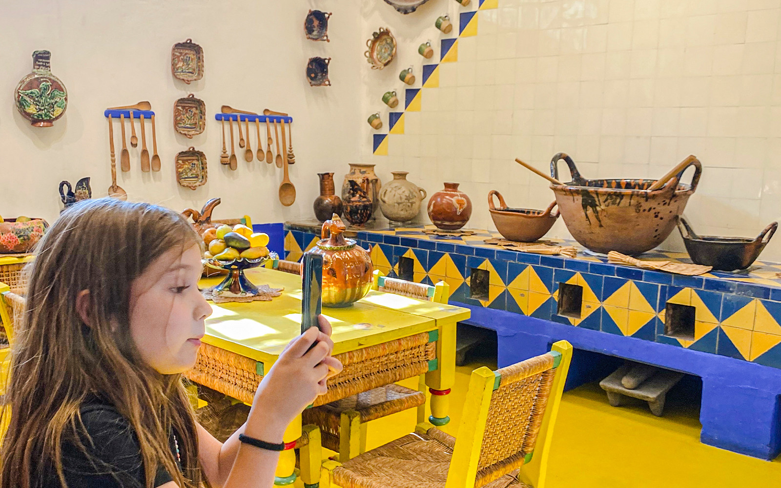 Frida Kahlo Museum kitchen with traditional pottery and utensils on display.