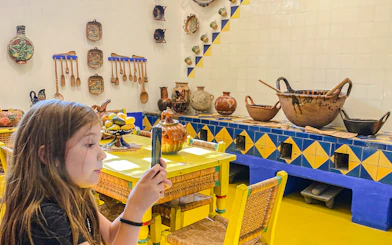 Frida Kahlo Museum kitchen with traditional pottery and utensils on display.