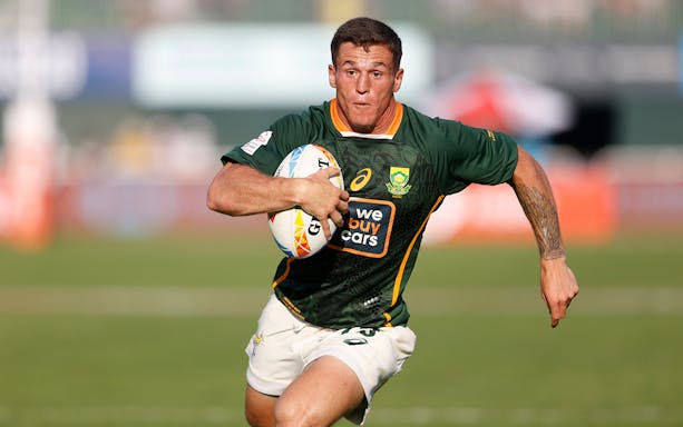 Rugby player running with ball at Emirates Dubai 7's tournament.