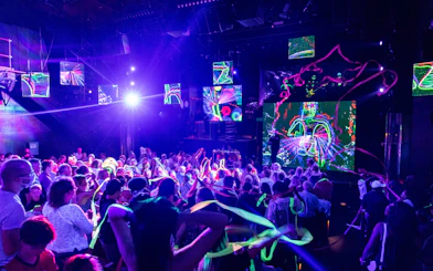 Blue Man Group performing on stage with vibrant lights and audience in Orlando.
