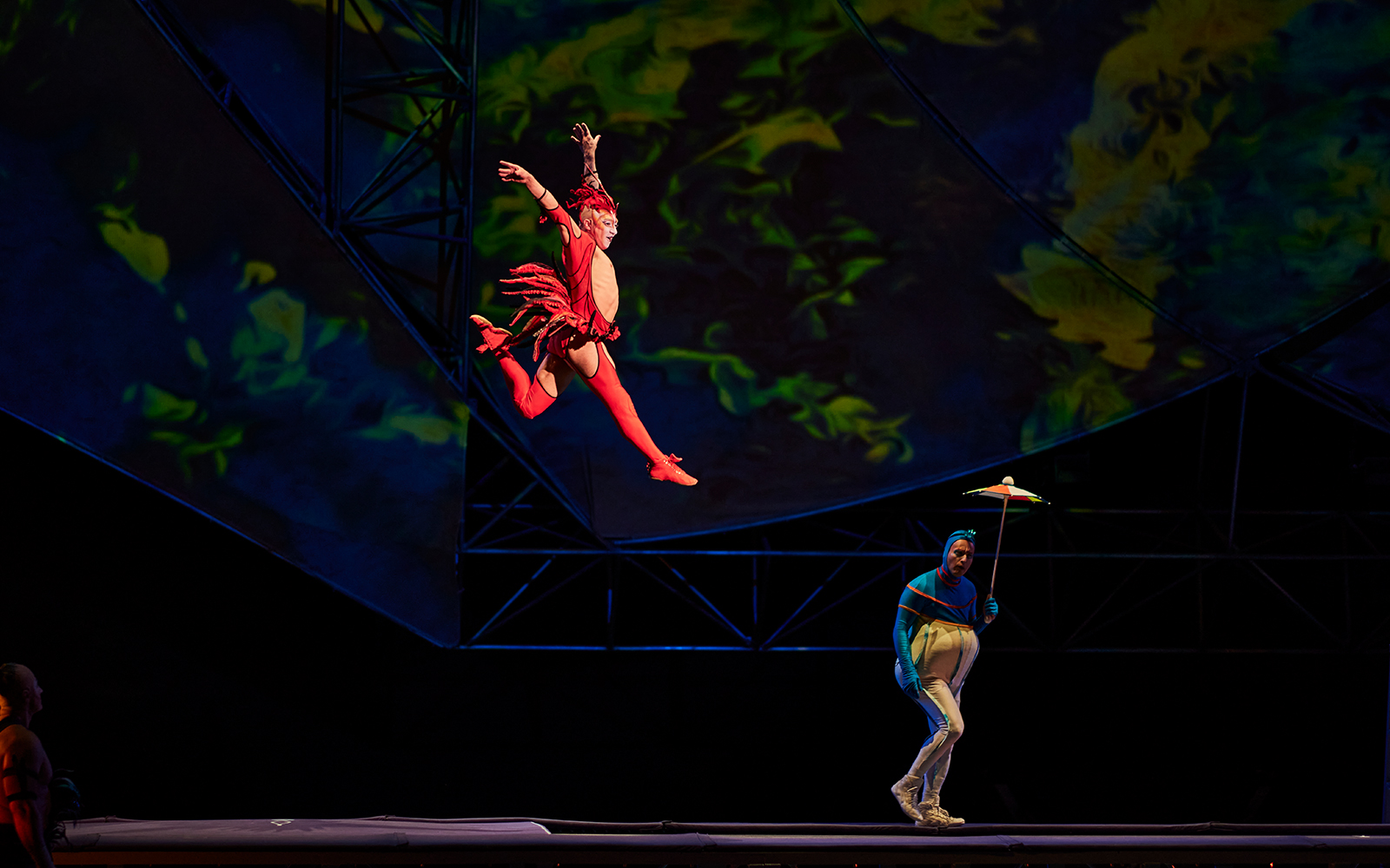 Performer in red costume leaping during Mystère show.