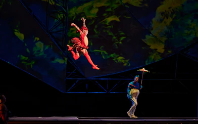 Performer in red costume leaping during Mystère show.