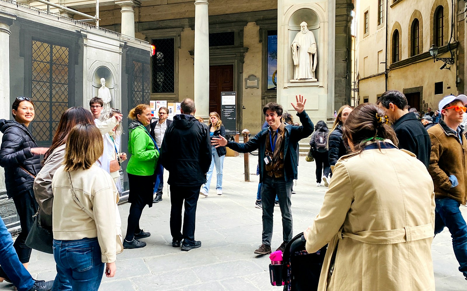Tour group gathering outside Uffizi Gallery with guide in Florence, Italy.