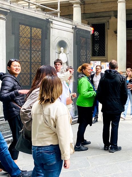 Tour group gathering outside Uffizi Gallery with guide in Florence, Italy.