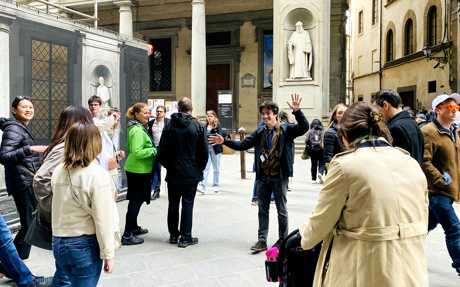 Tour group gathering outside Uffizi Gallery with guide in Florence, Italy.