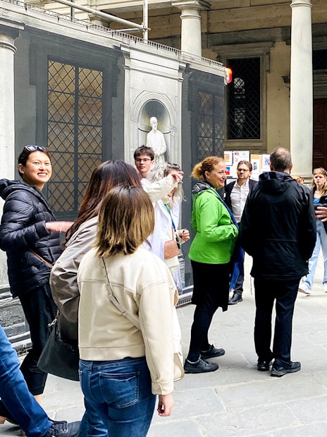 Tour group gathering outside Uffizi Gallery with guide in Florence, Italy.