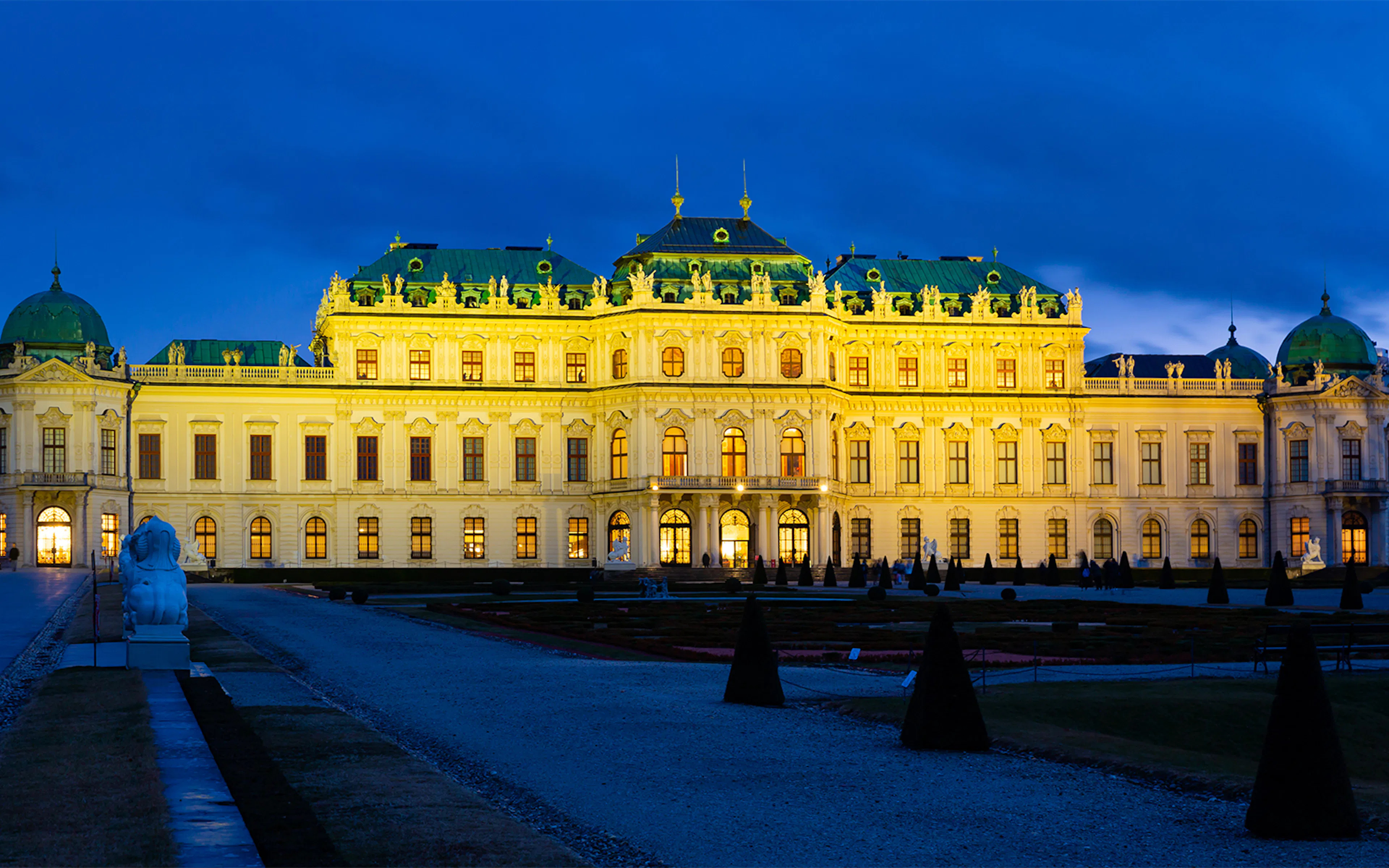 Illuminated Belvedere Palace in Vienna at night, showcasing Baroque architecture.