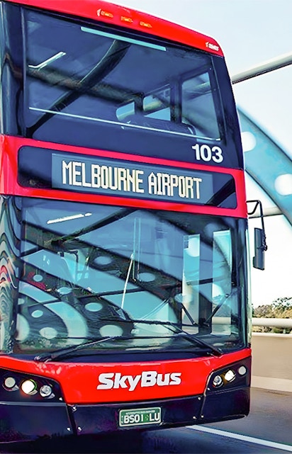 Skybus double-decker heading to Melbourne Airport on a highway bridge.